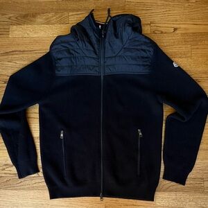 The "Moncler Maglione Tricot Cardigan" is a popular hybrid jacket with hood